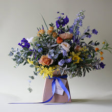 A bright, blue & beautiful bouquet with a golden touch, guaranteed to make an impact on Mother’s Day. Created with golden garden roses mixed with a Spring selection of muscari, narcissi, iris and ranunculus along with delphiniums, buttercups, Icelandic poppies, sandersonia & mimosa.